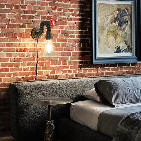 Water Pipe Wall Light Fixture Vintage Steampunk Sconce with plug-in cord next to a bed against a brick wall showcasing industrial style.