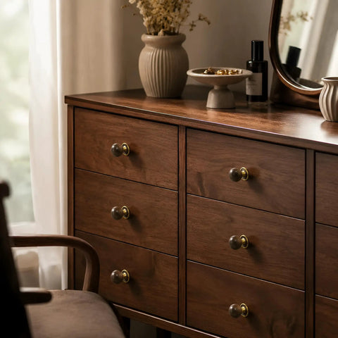 The Real Deal Natural Walnut And Antique Brass Cabinet Knobs Six Pack on a wooden dresser, showcasing round ball handles.