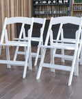 Hercules Series White Padded Folding Chair Set Of 4 Ultra Lightweight Event Seating With 800 Lb Capacity in wood-floored venue