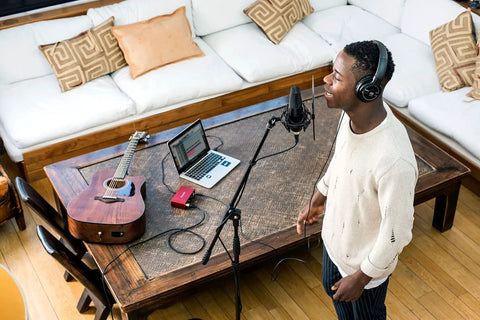 Home studio setup with Scarlett Solo 3rd Gen USB Audio Interface Bundle and LyxPro mic in use, guitar and laptop on wooden table