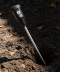 2-In-1 Soil Moisture Meter And PH Tester With A 12 Inch Probe in use, inserted into soil for lawn and garden plant care