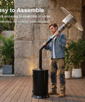 Man assembling 47000 BTU Outdoor Patio Heater With Round Table Design And Wheels Propane Gas Standing Heater with black hammered finish