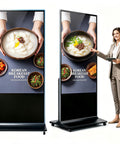 Top Shelf 65 Inch 4K UHD IPS Digital Signage Kiosk with food display and professional woman interacting.