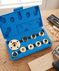 Kickass 11 Piece Brass Router Bushing Kit With Universal Lock Nuts And Heavy Duty Case open on a table with brass pieces visible.