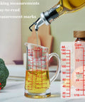Glass Measuring Cup 5 Oz 150 Ml Shot Glass with V Spout and Insulated Handle, filled with oil, on kitchen counter