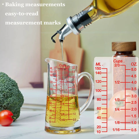 Glass Measuring Cup 5 Oz 150 Ml Shot Glass with V Spout and Insulated Handle, filled with oil, on kitchen counter