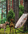 Camo Tree Hammock Chair For Huntin And Camping Portable Lightweight Stool on tree stand with two dogs in a forest setting
