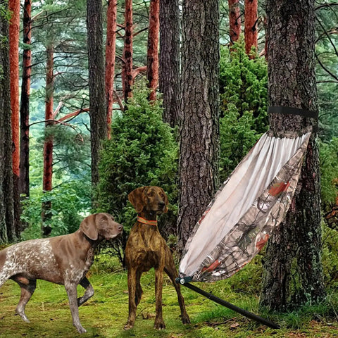 Camo Tree Hammock Chair For Huntin And Camping Portable Lightweight Stool on tree stand with two dogs in a forest setting