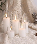 Clear Glass Flameless Candles With Remote Set Of 5 Slim Tall LED Pillar Candles on lace fabric, varied heights