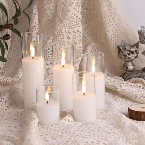 Clear Glass Flameless Candles With Remote Set Of 5 Slim Tall LED Pillar Candles on lace fabric, varied heights