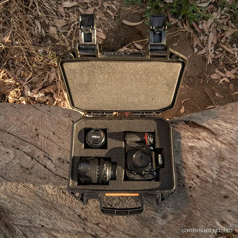 Vault V100 Tough As Nails Multi Purpose Hard Case with Foam holding camera gear, open on wood with outdoor background.