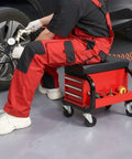 Mechanic using Tool Box With Built In Creeper Seat And Three Drawer Heavy Duty Tool Chest On Four Rolling Casters For Garage Shop Roller Seat And 350 Lb Capacity Sturdy Steel Construction for wheel repair.