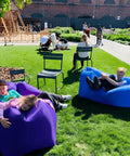 Children lounging on Inflatable Lounger Air Sofa Hammock For Outdoors Camping Beach And Festivals, in a park setting