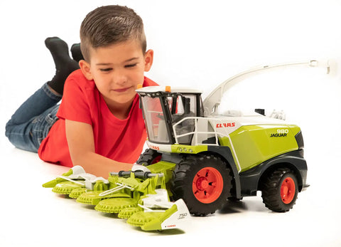 Young boy playing with CLAAS Jaguar 980 Field Chopper 1 16 Scale Model With Realistic Cab Details And Openable Doors A Premium Farm Toy