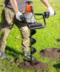 Person using Powerful Electric Post Hole Digger With 1500W Motor 5.91 Inch Auger Bit 140 RPM Alloy Steel Drill in grassy field.