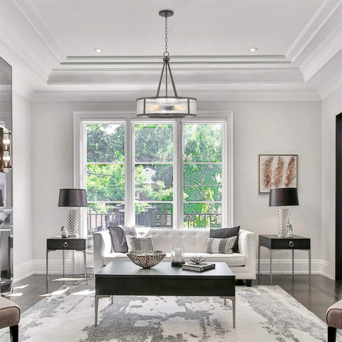 Living room with Cheyenne 23 Inch Four Light Modern Drum Chandelier With Rippled Glass Panel Shade in Galvanized Steel Finish.
