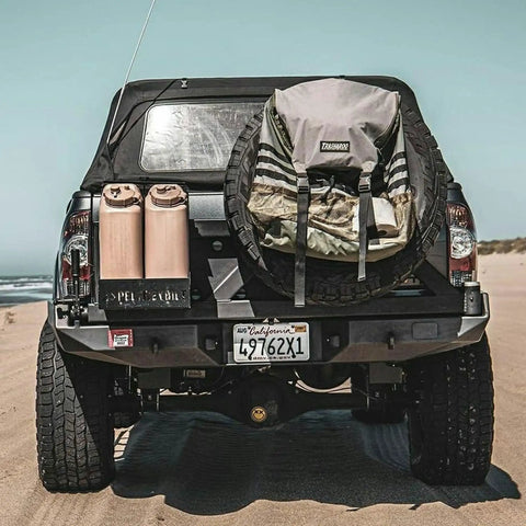 Truck with two sand-colored Portable 5 Gallon Military Style Water Jug For Camping And RVs Sand Colored Plastic Beverage And Hydration Dispenser.