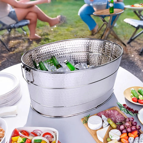 Aspen Heavy-Duty Oval Stainless Steel Drink Cooler For Parties 25-Quart Large Ice Bucket includes beverages and ice on table