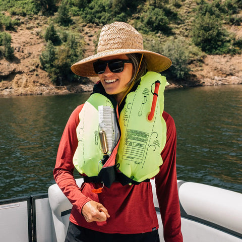 Person wearing USCG Approved Inflatable Life Jacket for Adults Go To Auto Or Manual Inflation Green 30 To 52 Inch Chest on boat