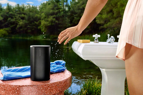 Take Anywhere Portable Bluetooth Speaker with WiFi Alexa Built In 24 Hour Battery Life beside outdoor sink by a lake.