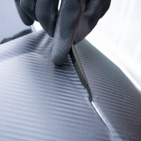 Close-up of vinyl cutter trimming vinyl on car, part of the 9 In 1 Vinyl Wrap Tools Kit With Heat Gun For Car Wrapping And Window Tinting