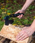 Outdoor Axe And Fixed Blade Knife Set With Full Tang And Wood Handle splitting wood outdoors, black handle visible