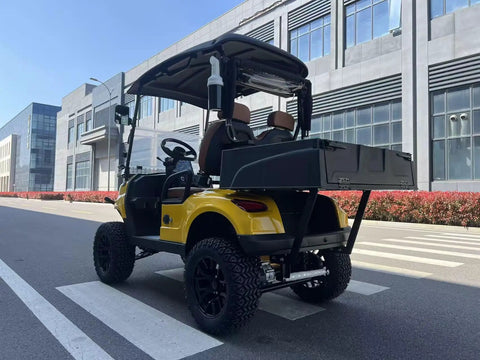 Yellow Electric Golf Cart Two Seater With Cargo Bed Rock Solid Frame Non Slip Tires Independent Suspension Full Led Lighting in urban setting.
