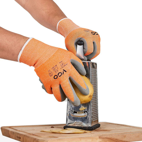 Person grating potato wearing ANSI A3 Cut Resistant Gloves with Latex Rubber Coated Grip, Size Large, Orange for hand protection.