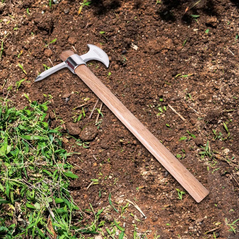 Stainless Steel Garden Pickaxe Tool For Digging And Soil Cultivation lying on soil with wooden ergonomic handle