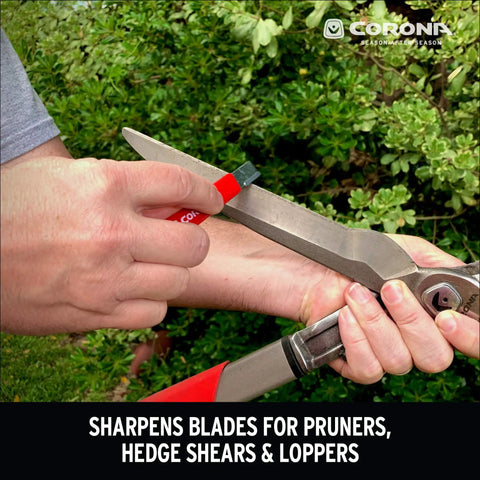 Person using handheld garden tool sharpener with tungsten carbide blade on pruning shears outdoors.