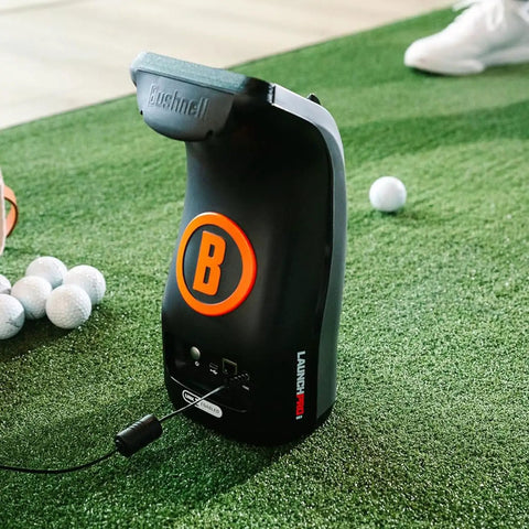 Launch Pro LPi Circle B Edition Indoor Golf Launch Monitor on green turf with golf balls and USB cable connected