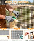 Person trimming Heavy Duty 1/4 Inch Black Vinyl Chicken Wire Fence Roll, 23 Gauge Rust Fighting Hardware Cloth for installation.