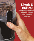 Hand pressing button on Fresh Grind Electric Coffee Grinder For Beans, Spices And More with stainless steel blades, black color.