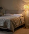 Rowan Brass Floor Lamp With Unique Thread Shade beside bed, glowing in a modern bedroom, Boho to Mid Century Decor, Tall Indoor