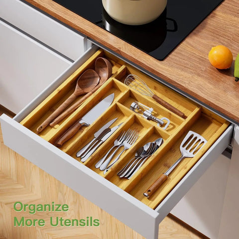 Expandable Bamboo Silverware Drawer Organizer with adjustable compartments in a kitchen drawer holding utensils and cutlery.