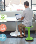 Man sitting on SitWell Wobble Stool With Adjustable Height For Active Seating In Classrooms And Libraries Grassy Green.
