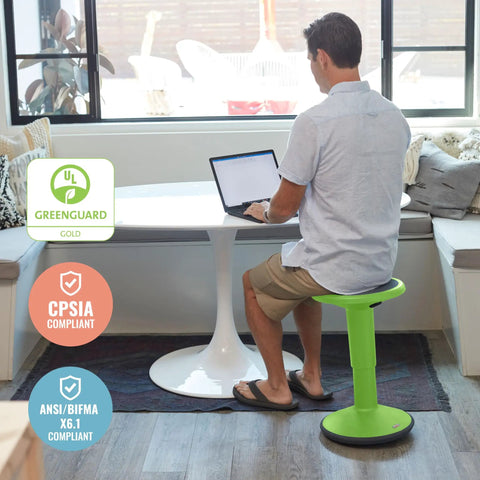 Man sitting on SitWell Wobble Stool With Adjustable Height For Active Seating In Classrooms And Libraries Grassy Green.