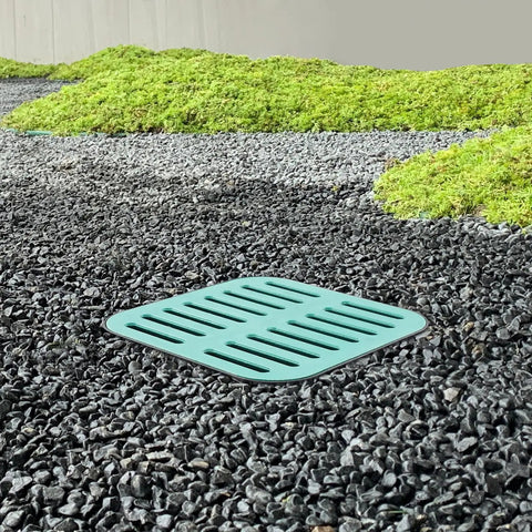 Heavy Duty Catch Basin With Grate And Debris Basket For Yard Drainage And Lawn Downspouts French Drain Systems No Reserved Hole Municipal Pipeline Pro Grade Durable Composite Resin Construction 15.7Inch Cube installed in gravel landscape