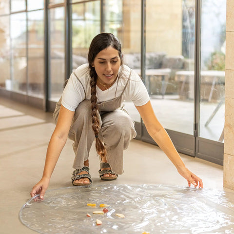 Woman placing Waterproof High Chair Floor Mat 50 Inch Diameter Clear Circle Kitchen Mat Protects Floors From Spills And Messes on floor