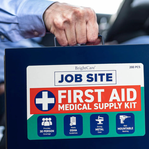 Front view of blue metal job-site first aid kit case held by hand, BrightCare label, 200-piece medical kit