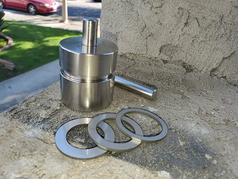 Total Game Changer Coin Ring Punch Set With Four Sleek Self Centering Tools for Relaxing Jewelry Crafting on a work surface.