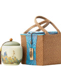Top Shelf Ceramic Tea Tin With Woven Rattan Travel Case, Stunning Mountain Landscape Design, Go To Stash Jar For Loose Leaf Tea Or Specialty Coffee Beans In Slate Blue next to its rattan pouch.