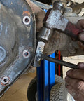 Mechanic using Gasket Separator Tool for oil pans transmission pans and differential covers with hardened carbon steel blade