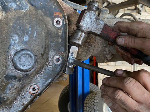 Mechanic using Gasket Separator Tool for oil pans transmission pans and differential covers with hardened carbon steel blade