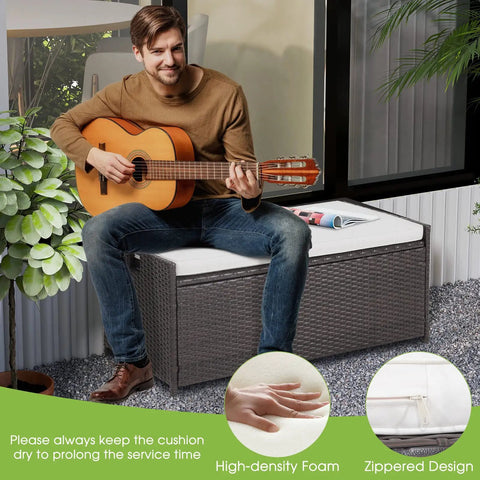 Man sitting on Outdoor 34 Gallon Storage Bench With Seat Cushion And Waterproof Liner, Wicker Brown Deck Box With Side Handles