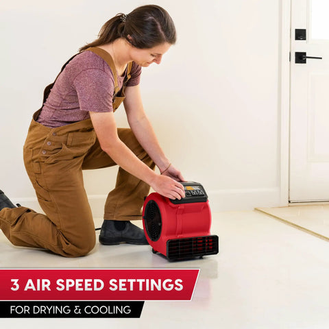 Woman adjusting Heavy Duty Three Speed Floor Fan With 156W 550 CFM Air Mover for quick drying and cooling in room