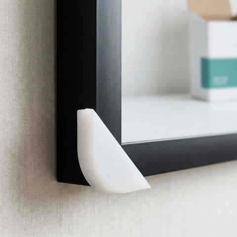 Pro Grade Protective Corner Guards for picture frames with durable plastic edge protector on black frame corner