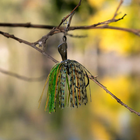 Weedless Bass Jig With Bladed Vibration Tech For Pike Walleye Muskie Six Color Lures Set on a branch. Chartreuse color visible.