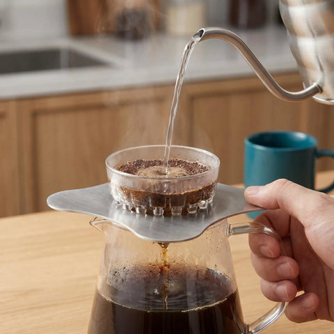 Total Game Changer Metal Coffee Drip Assist Tool And Portable Pour Over Dripper Stand with hot water pouring into filter.