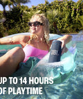 Woman relaxing in pool holding Grip Compact Bluetooth Speaker With Bold Pro Sound And Ambient Light For On The Go Vibes, Pink.